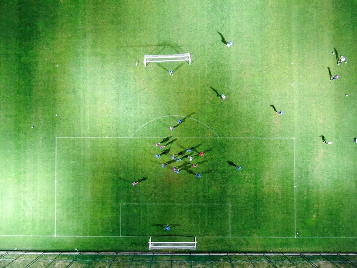 Aerial view of football team practice on field.