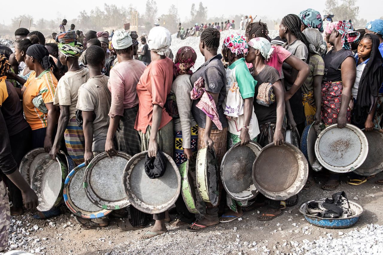 Women wait in line Saturday to collect their pay at Pissy Granite Mine in the center of Ouagadougou, the capital of Burkina Faso.