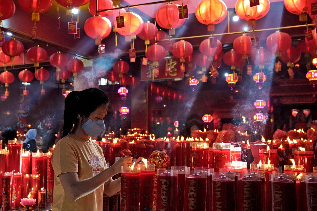 A woman lights a candle during the lunar New Year celebrations at the Hok Lay Kiong temple in Bekasi, Indonesia, on Tuesday.