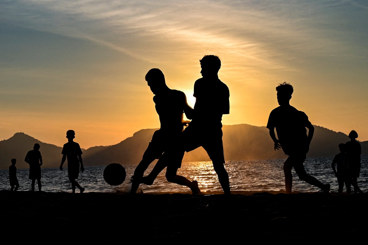 Youths play soccer along a beach as the sun sets in Banda Aceh, Indonesia, on Sunday.