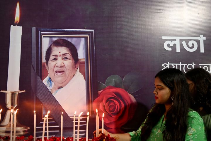 People pay tribute in front of a portrait of Bollywood singer Lata Mangeshkar, in Kolkata on February 6, 2022, after she died at the age of 92.