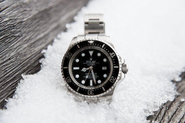 "Stuttgart, Germany - January 27, 2013: Rolex Oyster Perpetual DEEPSEA Seadweller Watch Reference 116660 outdoors on icy snow covered old wooden board."