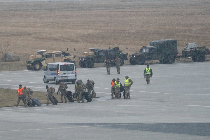 U.S. troops walk from a U.S. Air Force transport plane transporting military equipment and troops after landing at the Rzeszow-Jasionka airport in southeastern Poland on Sunday. The troops arrived as part of reinforcement due to tensions with Russia.