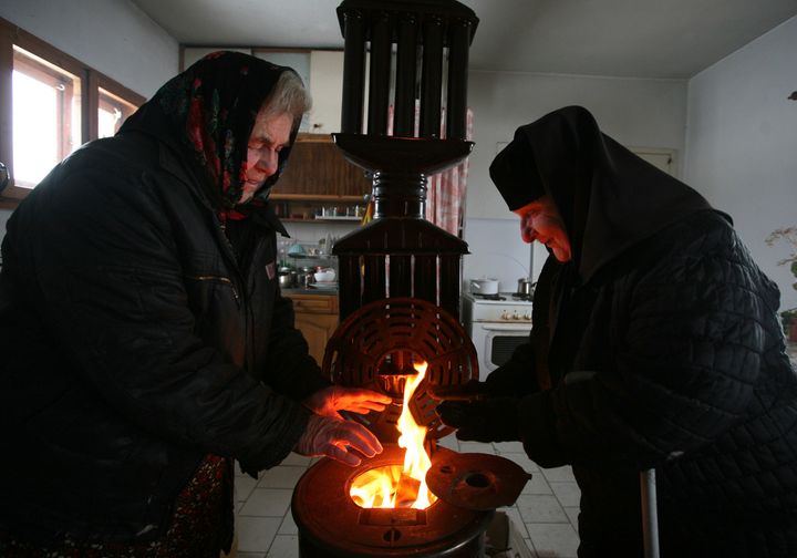 Mία καλόγρια και μία επισκέπτρια προσπαθούν να ζεσταθούν πάνω από μία ξυλόσομπα που καίει σε μοναστήριο κοντά στην πρωτεύουσα της Βουλγαρίας, Σόφια, την Παρασκευή 9 Ιανουαρίοου 2009. Οι φόβοι πολλαπλασιάζονται σχετικά με το τι θα μπορούσε να συμβεί σε σχέση με την ενεργειακή επάρκεια της Ευρώπης αν η Ρωσία εισβάλει στην Ουκρανία και κατόπιν διακόψει τη ροή φυσικού αερίου, ως απάντηση σε πιθανές αμερικανικές και ευρωπαϊκές κυρώσεις. (AP Photo/Petar Petrov, File)