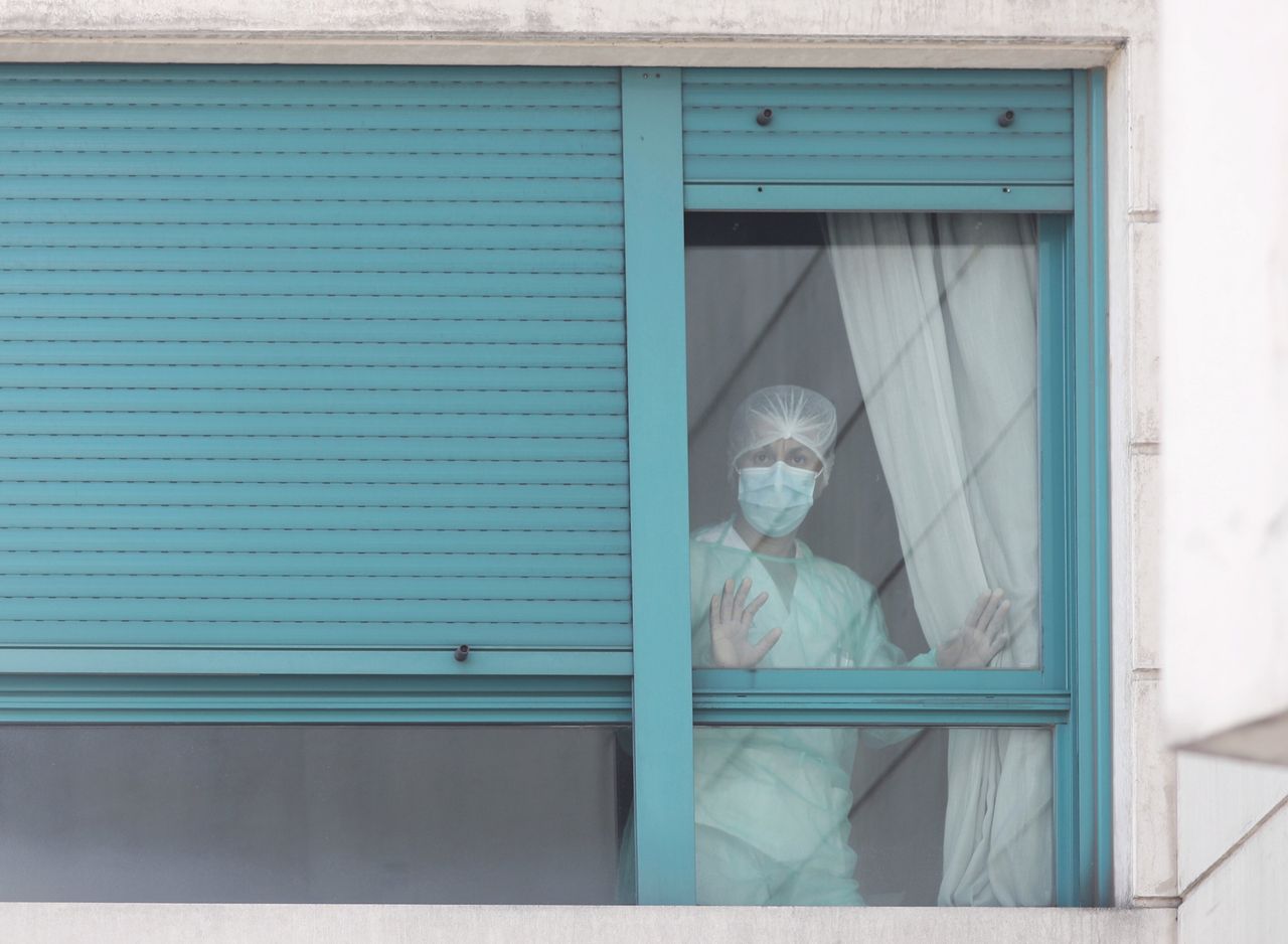 A health worker at ORPEA Madrid Buenavista nursing home looks through a window on March 25, 2020, in Madrid.