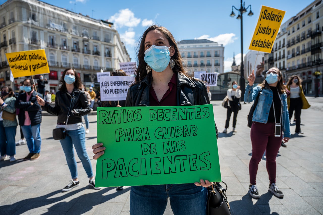 A nurse carrying a placard reading "decent ratios to take care of my patients" during International Nurses Day on May 12, 2021. Nurses were protesting against their mistreatment during the coronavirus pandemic and demanding more resources.