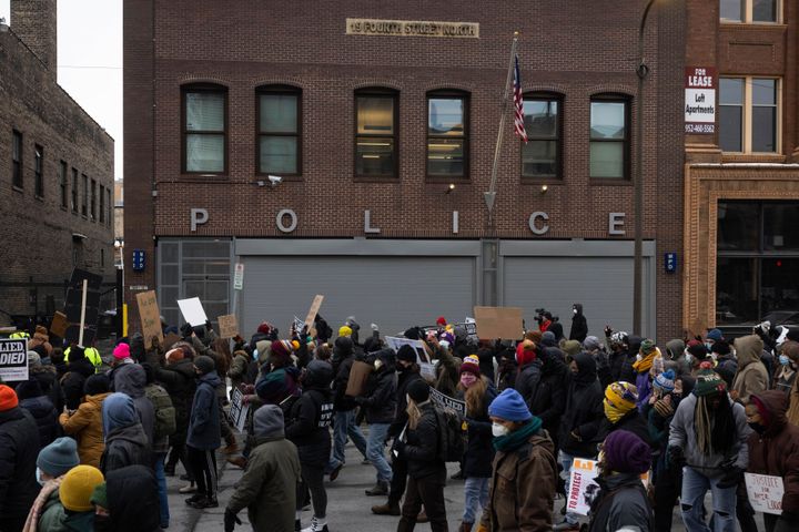 Demonstrators march past a police precinct during a rally for Amir Locke on Saturday in Minneapolis. Hundreds of people filled the streets of downtown Minneapolis after bodycam footage showed an officer killing Locke during a no-knock warrant.