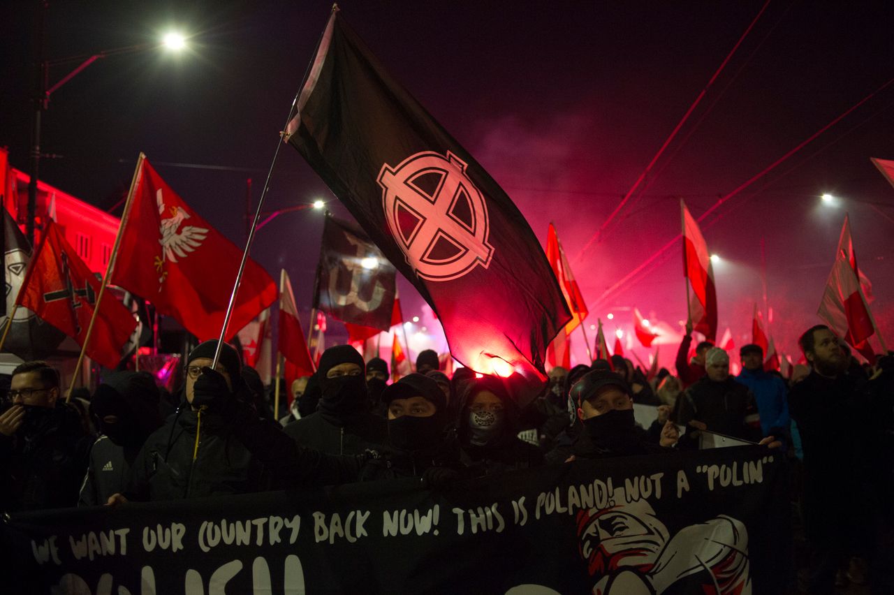 Far-right protesters — seen here waving a flag with the <a href="https://www.adl.org/education/references/hate-symbols/celtic-cross" target="_blank" role="link" class=" js-entry-link cet-external-link" data-vars-item-name="white supremacist version of the Celtic Cross" data-vars-item-type="text" data-vars-unit-name="620293abe4b0725faad01783" data-vars-unit-type="buzz_body" data-vars-target-content-id="https://www.adl.org/education/references/hate-symbols/celtic-cross" data-vars-target-content-type="url" data-vars-type="web_external_link" data-vars-subunit-name="article_body" data-vars-subunit-type="component" data-vars-position-in-subunit="11">white supremacist version of the Celtic Cross</a> — march in Warsaw, Poland, in November 2019 to commemorate Poland's independence. The annual march regularly attracts white supremacists. In 2019, it attracted members of the American white supremacist group Patriot Front.