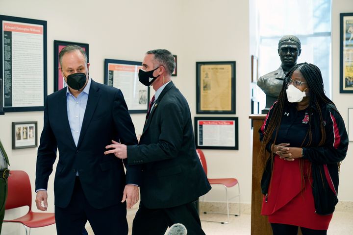 Doug Emhoff, the husband of Vice President Kamala Harris, is whisked out of an event at a high school by a Secret Service agent following an apparent security concern, Tuesday, Feb. 8, 2022 in Washington. On the far right is Nadine Smith, Dunbar principal. 