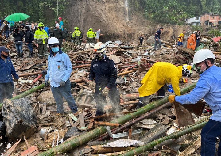 Autoridades y miembros de cuerpos de rescate trabajan en una zona afectada por un deslizamiento de tierra, en Colombia.