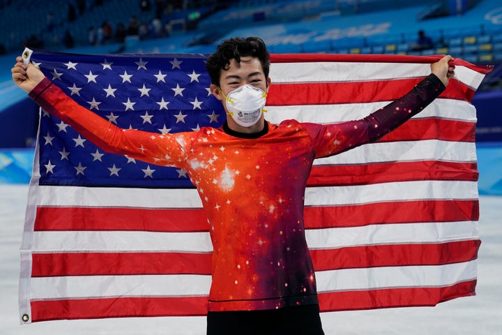 Nathan Chen, of the United States, holds his national flag as he celebrates after winning the gold medal in the men's free skate program during the figure skating event at the 2022 Winter Olympics on Thursday.