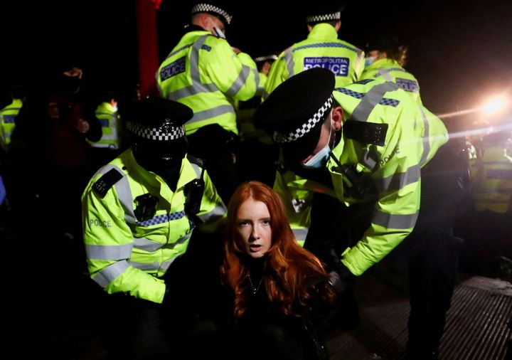 Police detain Patsy Stevenson as people gathered at a memorial site following the kidnap and murder of Sarah Everard.