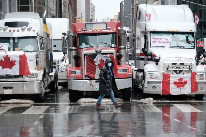 People walk near Canadian Parliament buildings as hundreds of truck drivers and their supporters gather to block the streets of downtown Ottawa as part of a convoy of truck protesters against Covid mandates in Canada on February 10, 2022 in Ottawa, Ontario.