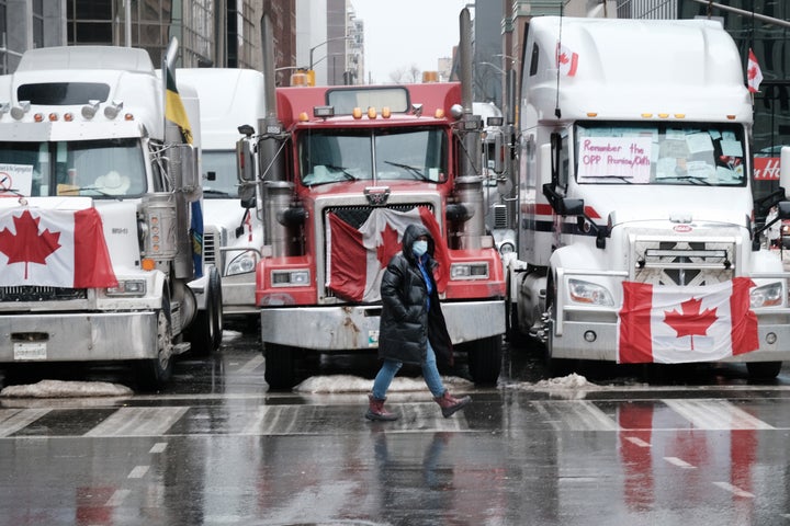 People walk near Canadian Parliament buildings as hundreds of truck drivers and their supporters gather to block the streets of downtown Ottawa as part of a convoy of truck protesters against Covid mandates in Canada on February 10, 2022 in Ottawa, Ontario.