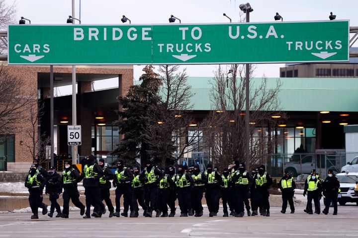 Police move into position to enforce an injunction against a demonstration which has blocked traffic across the Ambassador Bridge by protesters against COVID-19 restrictions, in Windsor, Ontario.