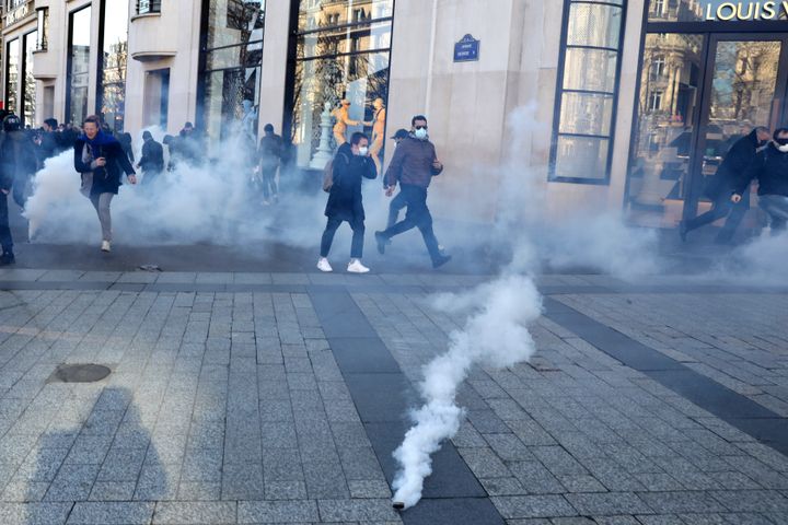 A tear gas grenade lands during a protest on the Champs-Elysees.