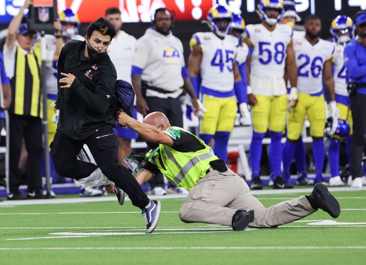 An unidentified fan is tackled by security after running onto the field during the second half of Super Bowl LVI at SoFi Stadium on Sunday, Feb. 13, in Inglewood, California.