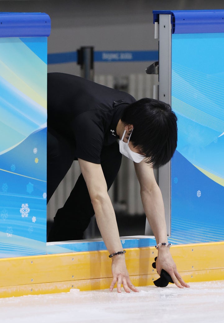 練習を終え、リンクに触れるフィギュアスケート男子の羽生結弦＝14日、中国・北京