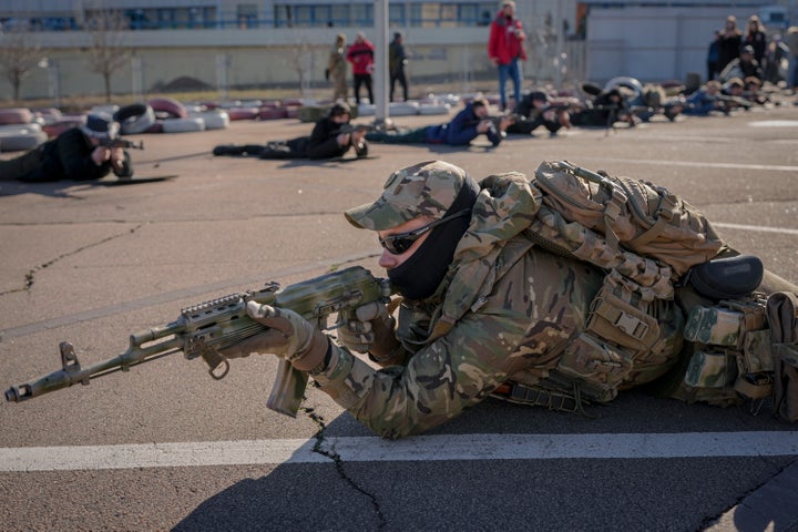 A member of the Special Forces Unit Azov, of Ukraine's National Guard, demonstrates a shooting position during a basic combat training for civilians in Mariupol, Donetsk region, eastern Ukraine, Sunday, Feb. 13, 2022. (AP Photo/Vadim Ghirda)