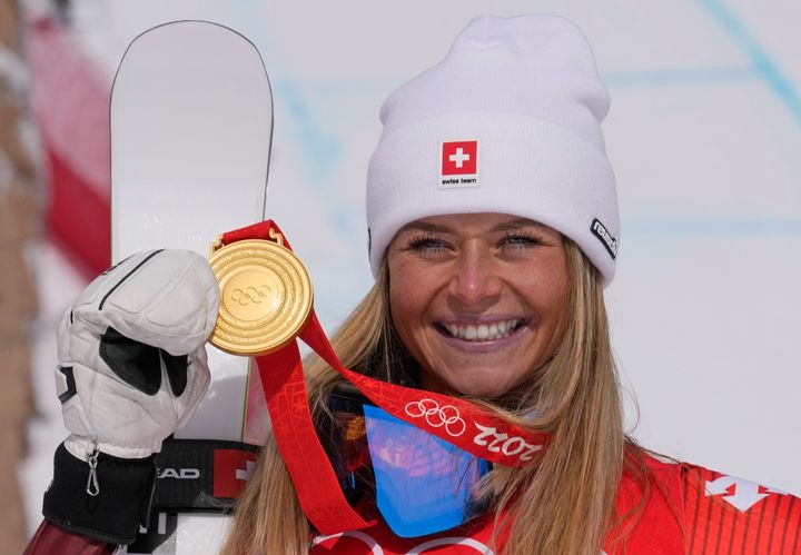 Corinne Suter, of Switzerland, gold, reacts during the medal ceremony for the women's downhill at the 2022 Winter Olympics.