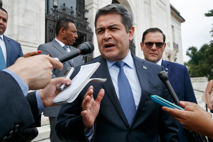 Juan Orlando Hernández answers questions from the Associated Press, on Aug. 13, 2019, as he leaves a meeting at the Organization of American States, in Washington, D.C.