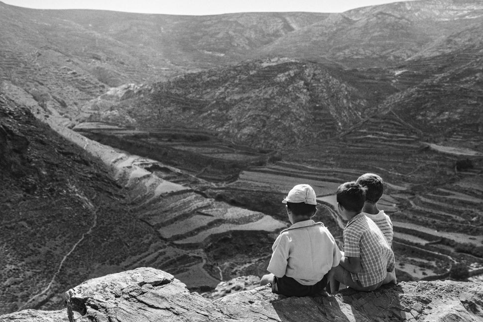 Kαθισμένοι στο αρχαίο τείχος, ο Γιάννης, ο Ηλίας και ο Ματθαίος κοιτάζουν τα βουνά, μεταξύ ανατολής και νότου, προς την κατεύθυνση του Αγίου Μάμα (από τα κείμενα του Νίκου Μαστροπαύλου) 