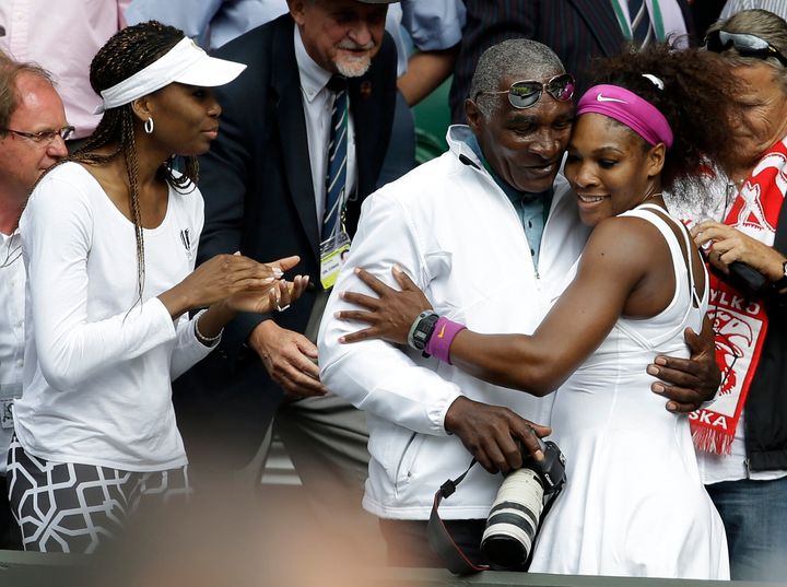 Venus Williams (left) and Serena Williams (right) with their father (center) at Wimbledon in 2012. 