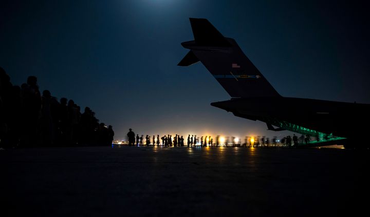 Evacuees board a U.S. Air Force C-17 Globemaster III aircraft at Hamid Karzai International Airport in Kabul on Aug. 21, 2021.