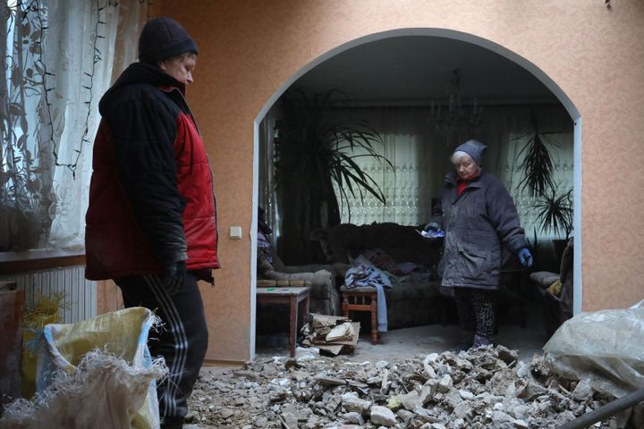 Local residents of the Ukrainian-controlled village of Stanytsia Luhanska, Luhansk region, clean up debris from homes after shelling by Russia-backed separatists on February 18, 2022. (Photo by Aleksey Filippov/AFP via Getty Images)