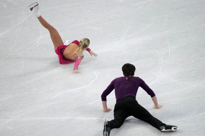 Kirsten Moore-Towers and Michael Marinaro, of Canada, fall in the pairs short program during the figure skating competition at the 2022 Winter Olympics.