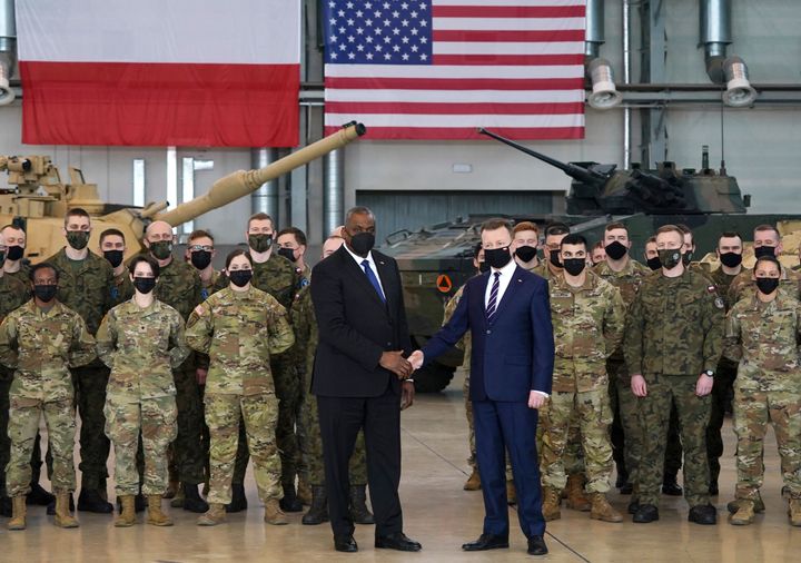 US Secretary of Defence Lloyd Austin (L) shakes hands with Polish Defence Minister Mariusz Blaszczak in front of Polish and US soldiers at the 33rd Air Base of the Polish Air Force near Powidz, central Poland on February 18, 2022.