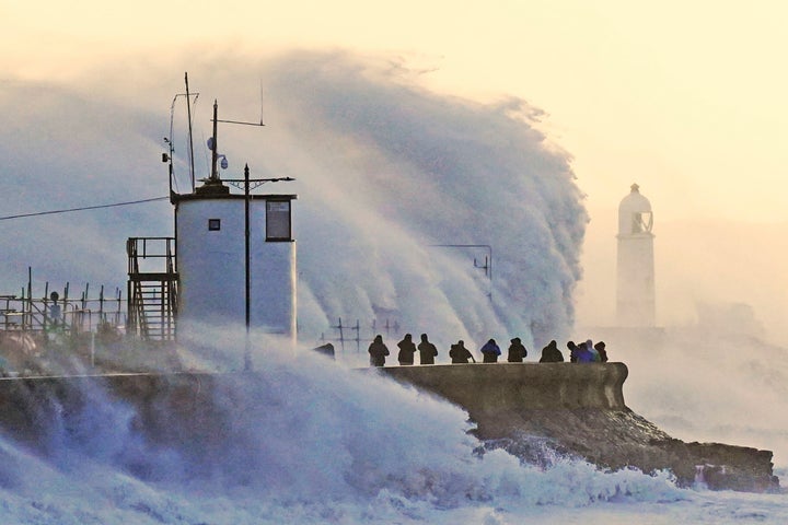 Waves crash against the sea wall and Porthcawl Lighthouse in Porthcawl, Bridgend, Wales,, Britain, as Storm Eunice makes landfall Friday, Feb. 18, 2022.
