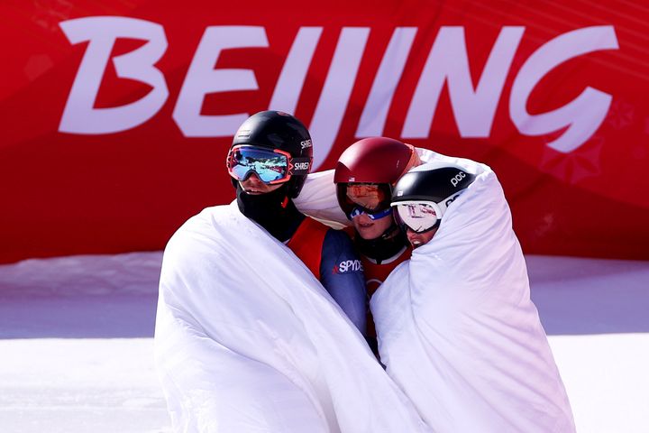 Mikaela Shiffrin, center, huddles with U.S. teammates Tommy Ford and Paula Moltzan after the mixed team parallel final.