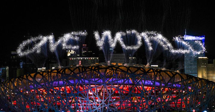 Fireworks spelling out "One World" explode over the Beijing National Stadium during the closing ceremony. 