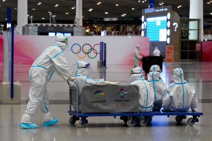 Volunteers ride on a cart at Beijing-Capital International Airport after the conclusion of the 2022 Winter Olympics, Sunday, Feb. 20, 2022, in Beijing. (AP Photo/Ashley Landis)