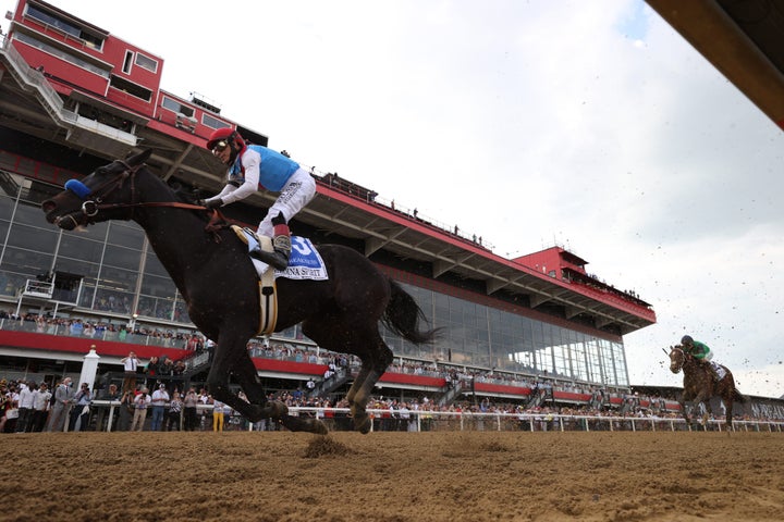 Jockey John Velazquez aboard Medina Spirit (3) in action, leading during race at Pimlico Race Course.