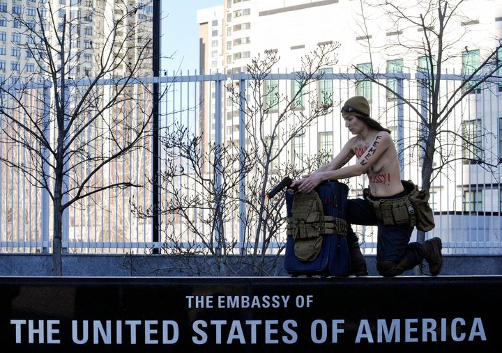 Ήδη από τις 15 Φεβρουαρίου 2022 η Αμερικανική Πρεσβεία στο Κίεβο είχε πρακτικά εγκαταλειφθεί με την σημαία των ΗΠΑ να έχει υποσταλεί. Την ημέρα εκείνη, μία γυμνόστηθη ακτιβίστρια της ομάδας Femen φωτογραφιζόταν συμβολικά μπροστά στο κτίριο της πρεσβείας ανενόχλητη. Την ίδια ημέρα ο Τζο Μπάιντεν προειδοποιούσε για πρόθεση Πούτιν να επιτεθεί στην Ουκρανία. (Photo by Sergei Chuzavkov/SOPA Images/LightRocket via Getty Images)