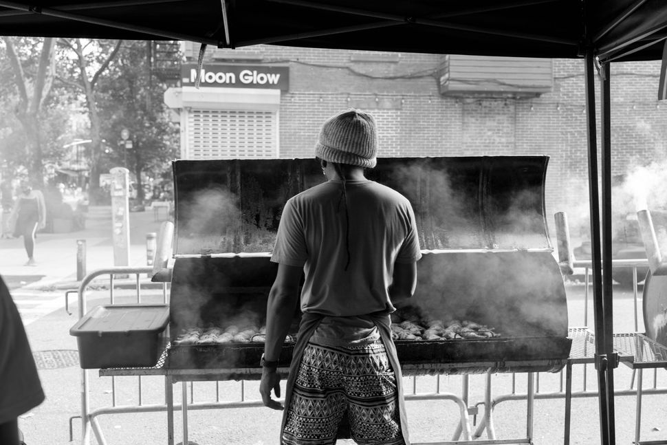 Brods, from Wadadli Jerk, grilling jerk chicken at a Tompkins Avenue block party in Brooklyn, New York, in 2021.