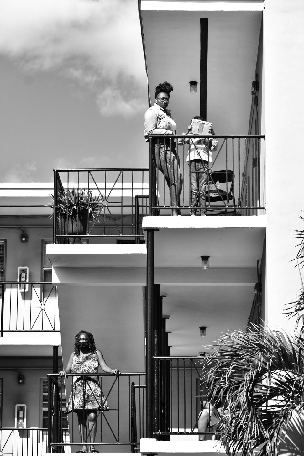 Democracy: Residents of a housing project in Miami watch the 2022 Martin Luther King Jr. Day Parade. The photograph evokes how Black Americans have often been positioned as onlookers even though they are the invisible hand in the creation of American democracy.