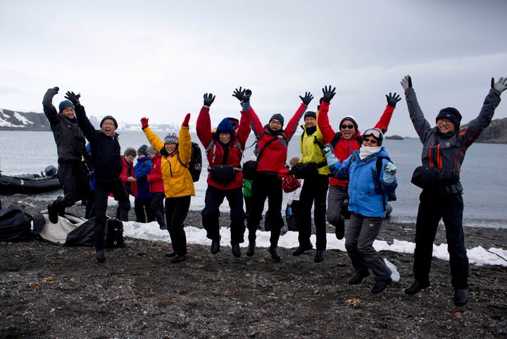 2 Φεβρουαρίου 2015. Τουρίστες πανηγυρίζουν ποζάροντας για φωτογραφία, έπειτα από την αποβίβασή τους από το κρουαζιερόπλοιο Ocean Nova, στη νήσο Βασιλεύς Γεώργιος στην Ανταρκτική. Tην συγκεκριμένη τουριστική σεζόν - από το Νοέμβριο μέχρι τον Μάρτιο δηλαδή - περισσότεροι από 37,000 αναμενόταν να πατήσουν στην πιο παγωμένη ήπειρο του πλανήτη. Αύξηση 10% της τουριστικής κίνησης σε σύγκριση με το προηγούμενο έτος. (AP Photo/Natacha Pisarenko)