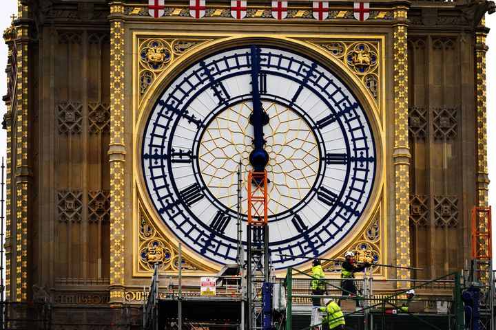 Construction workers remove the scaffolding from the restored west dial of the clock on Elizabeth Tower, known as Big Ben, at the Palace of Westminster.