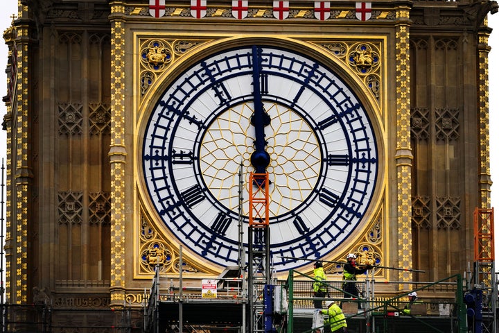 Construction workers remove the scaffolding from the restored west dial of the clock on Elizabeth Tower, known as Big Ben, at the Palace of Westminster.