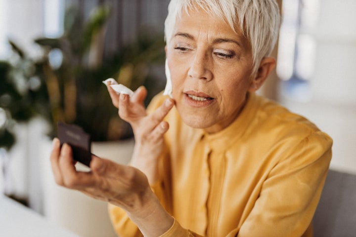 Senior woman applying makeup