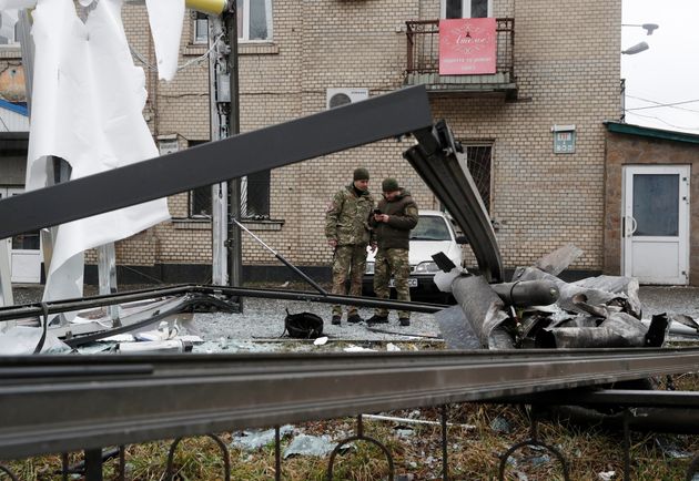 ロシアのプーチン大統領がウクライナ東部での軍事作戦を許可した後、路上に落ちたミサイルの残骸を点検する警察官（ウクライナ・キエフ、2022年2月24日撮影）。REUTERS/Valentyn