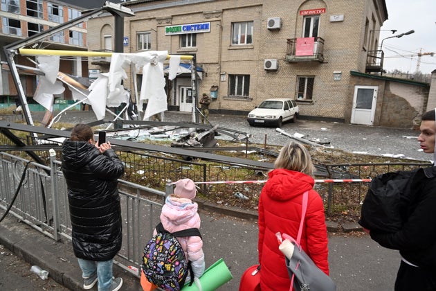 Des habitants près du lieu d'impact d'un obus russe à Kiev le 24 février