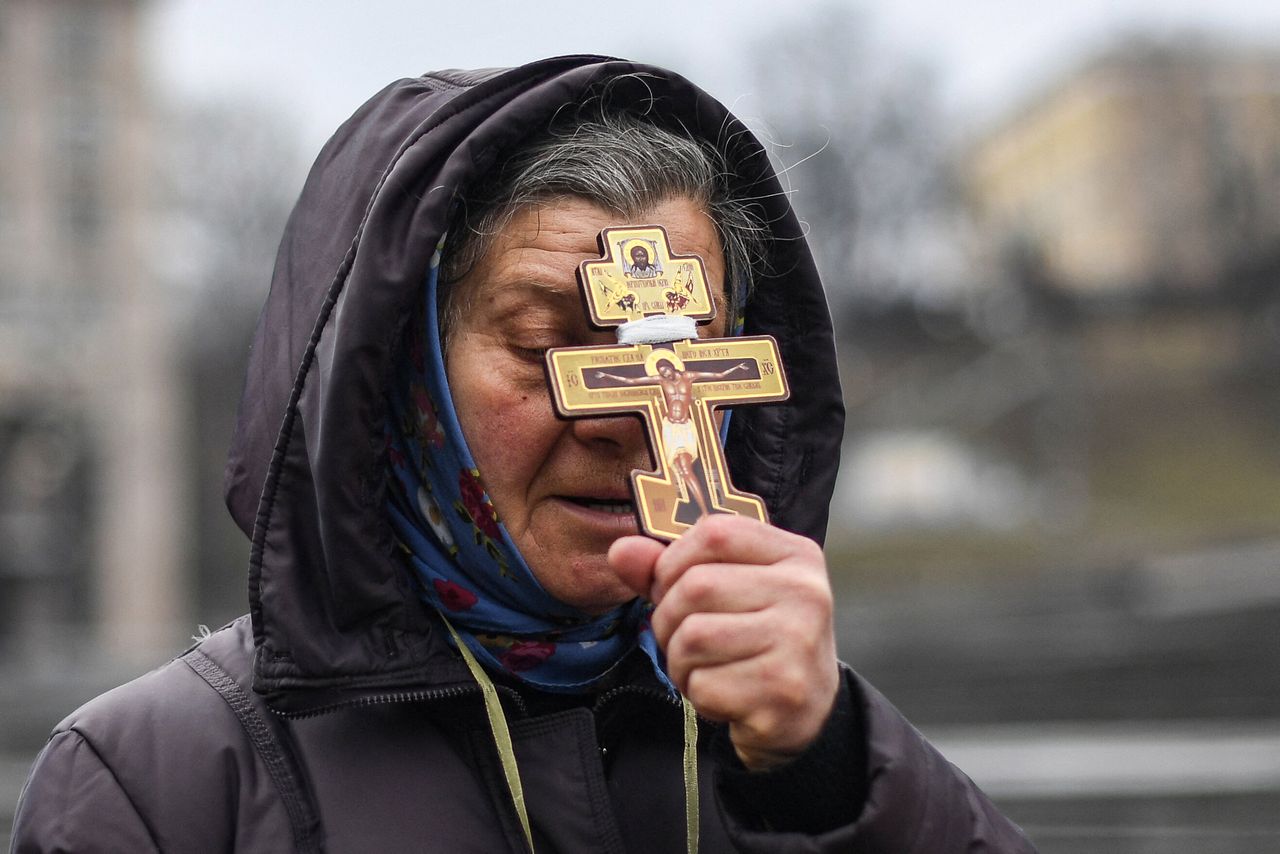 A woman holds a cross as she prays on Independence Square in Kyiv.