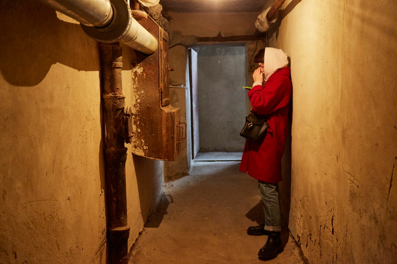 Local residents follow the news on their mobile devices in a Kyiv bomb shelter.