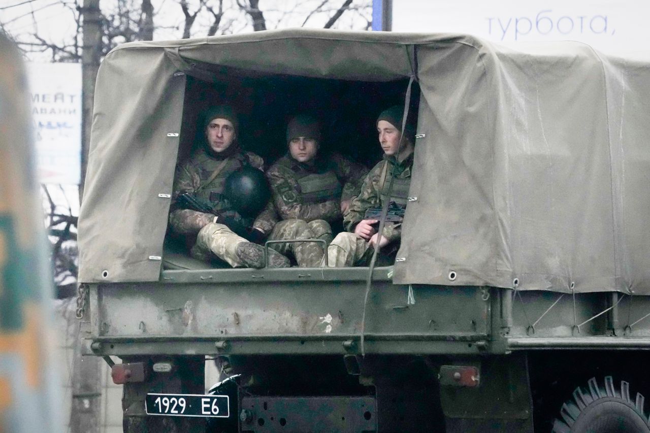 Ukrainian soldiers ride in a military vehicle in Mariupol.