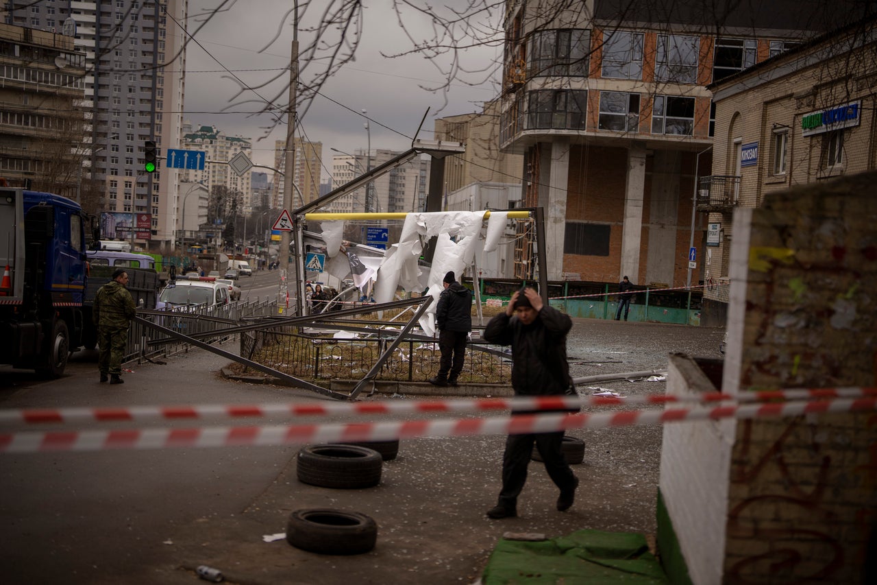 Police officers inspect the scene following an apparent Russian strike in Kyiv.