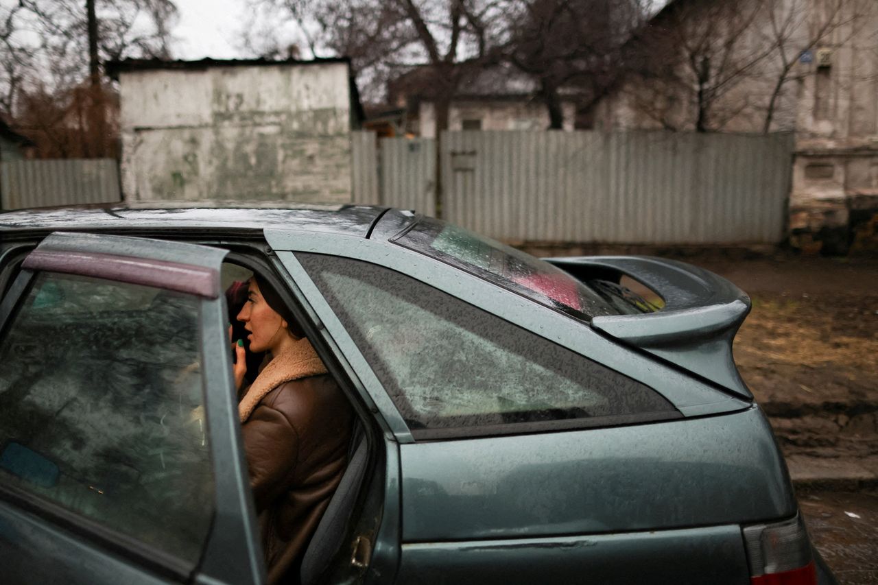 A resident in Mariupol sits in a car before leaving the city, after Putin authorized a military operation in the eastern Ukrainian city.